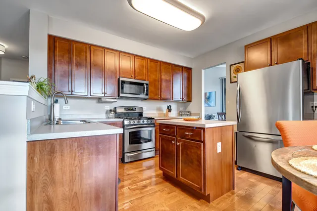 a kitchen with stainless steel appliances granite countertop a refrigerator stove and a sink with large countertops