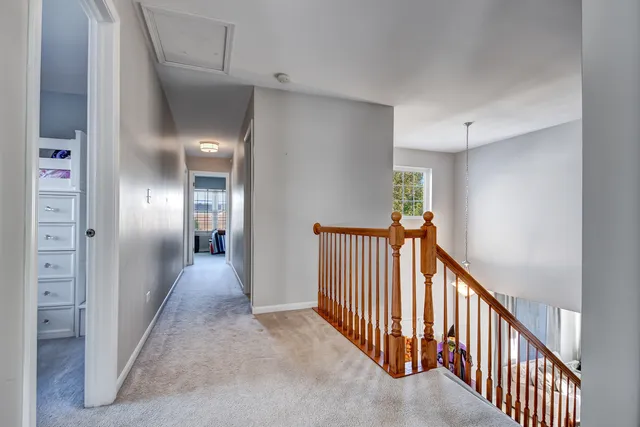a view of a hallway with a livingroom and stairs