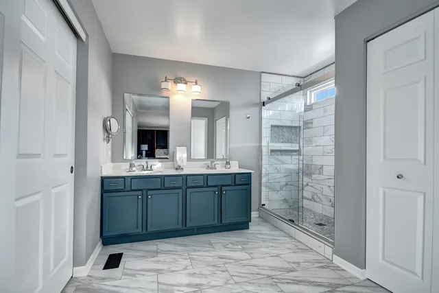 a bathroom with a granite countertop sink mirror and shower