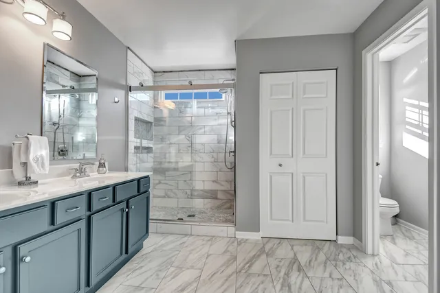 a bathroom with a granite countertop sink toilet and shower
