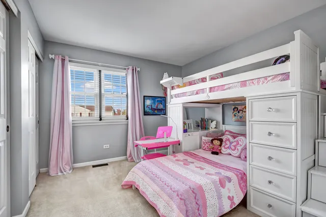 a bedroom with a bed and large windows