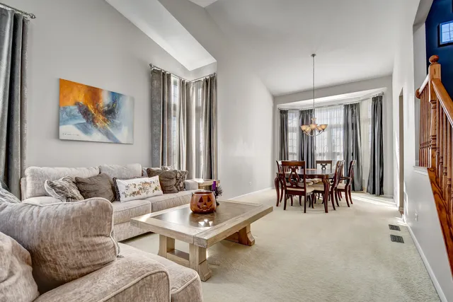 a living room with furniture a chandelier and a dining table