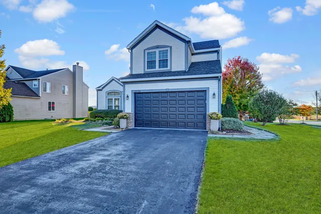 a view of a house with a yard and sitting area
