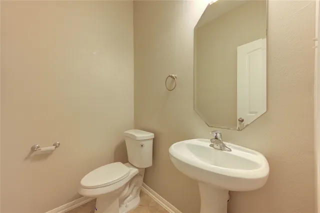 a bathroom with a sink a toilet and mirror