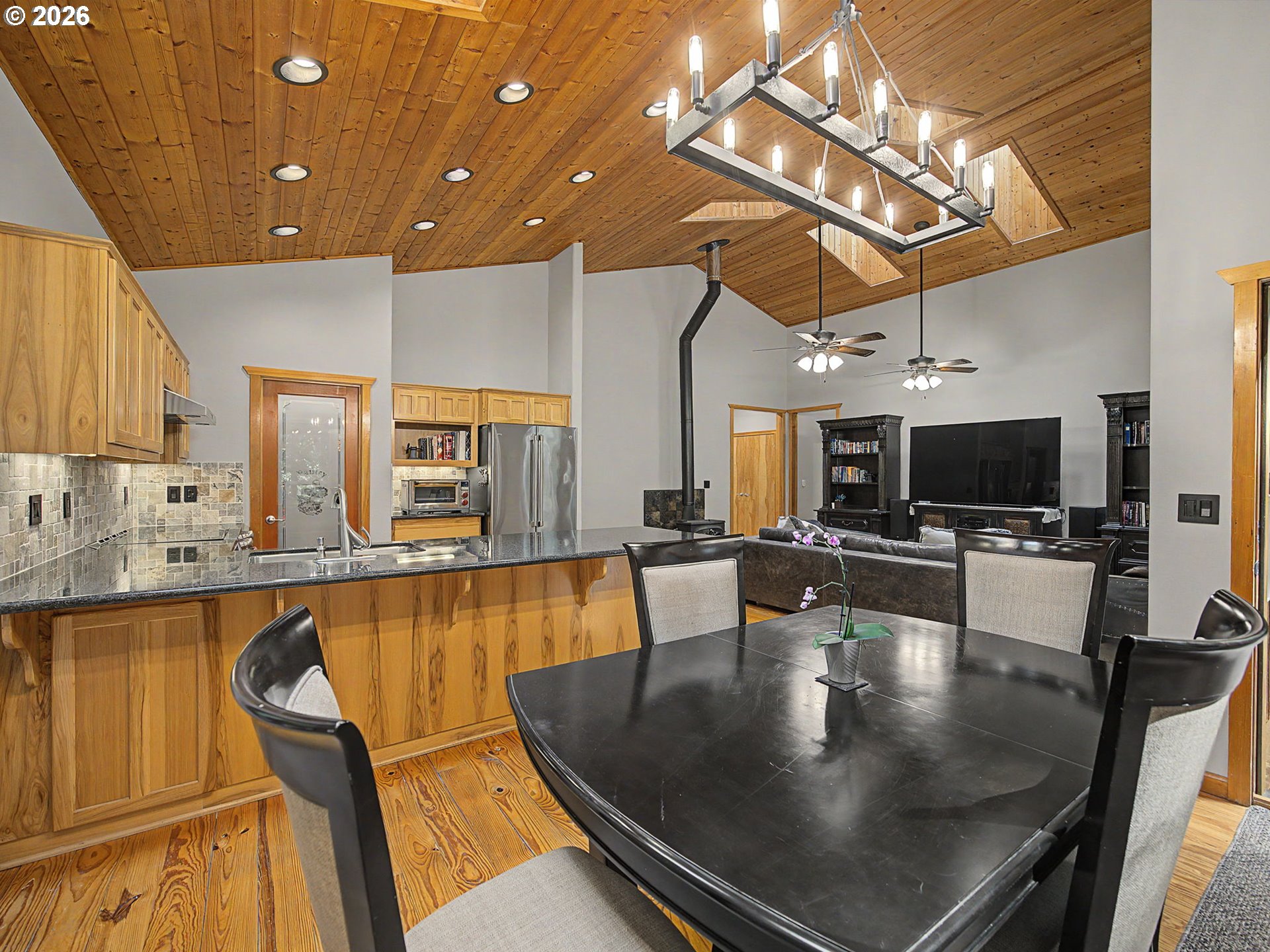 23491 East Lolo Pass Road Rhododendron, OR 97049 - Photo 14 of 47 a view of a dining room with furniture a chandelier and wooden floor