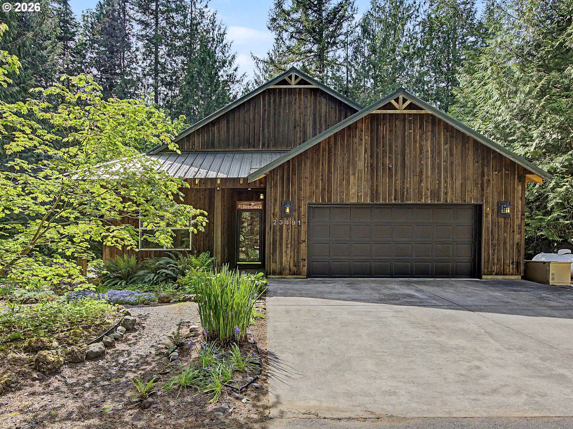 23491 East Lolo Pass Road Rhododendron, OR 97049 - Photo 2 of 47 a front view of a house with a yard and garage