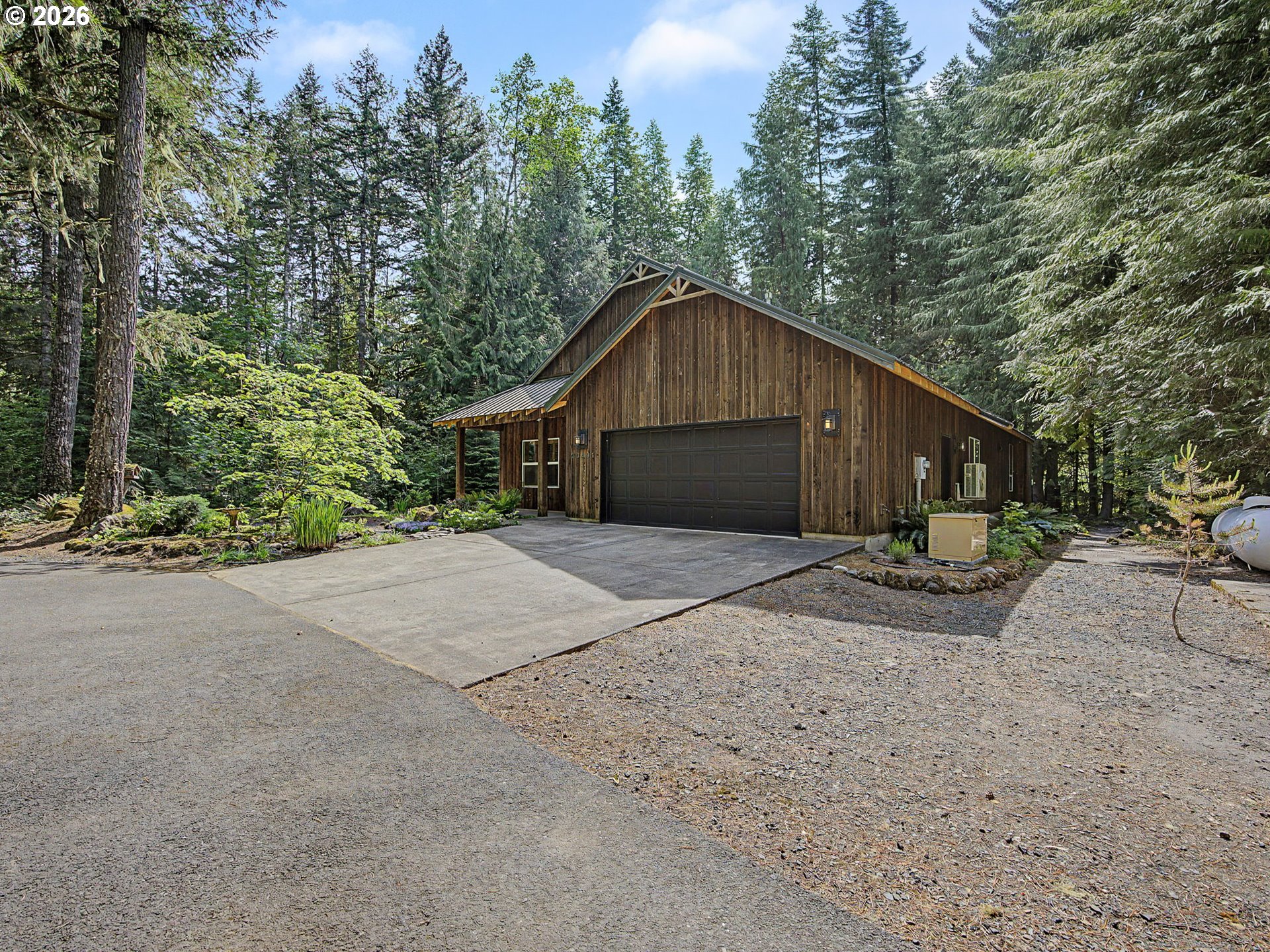 23491 East Lolo Pass Road Rhododendron, OR 97049 - Photo 4 of 47 a front view of a house with a yard and garage