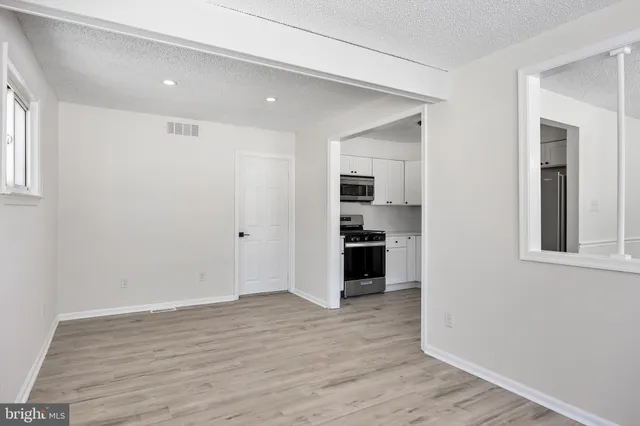 a view of a kitchen with wooden floor electronic appliances and windows