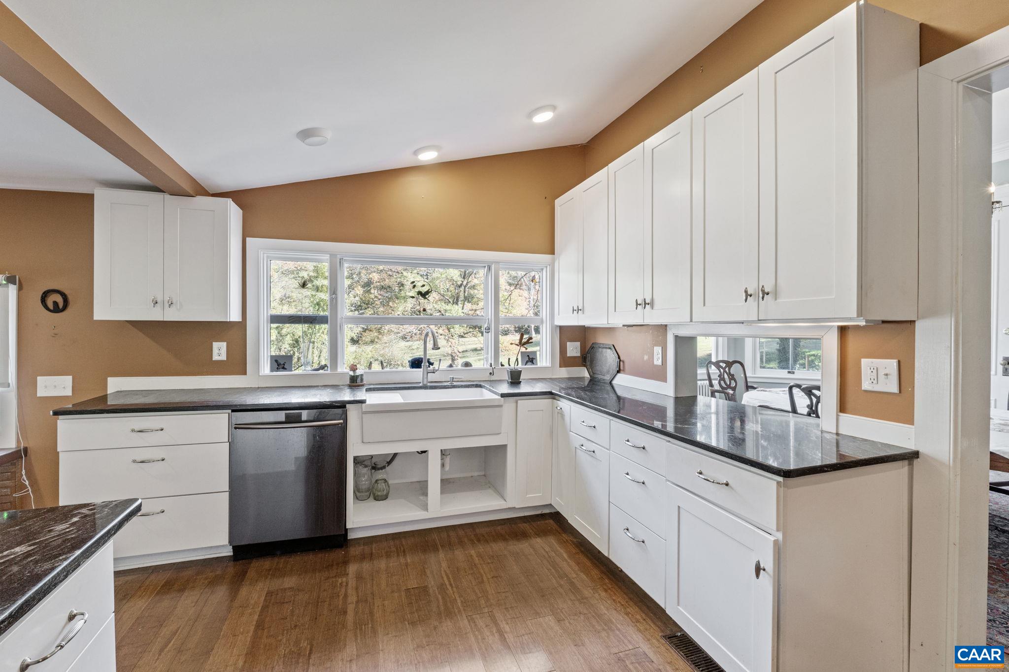 5515 Gordonsville Road Keswick, VA 22947 - Photo 25 of 74 a kitchen with stainless steel appliances granite countertop a stove a sink and white cabinets with wooden floor