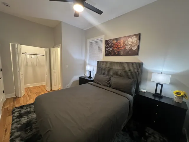 a bedroom with a bed and a lamp on dresser