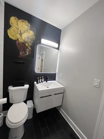 a bathroom with a toilet sink and mirror