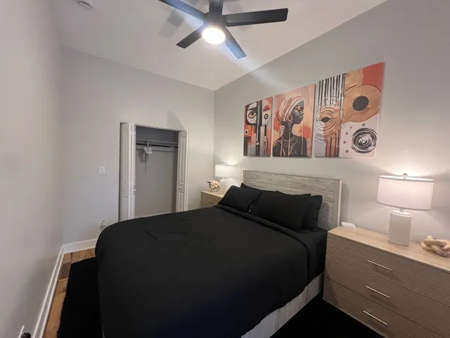 a bedroom with a bed and a lamp on dresser