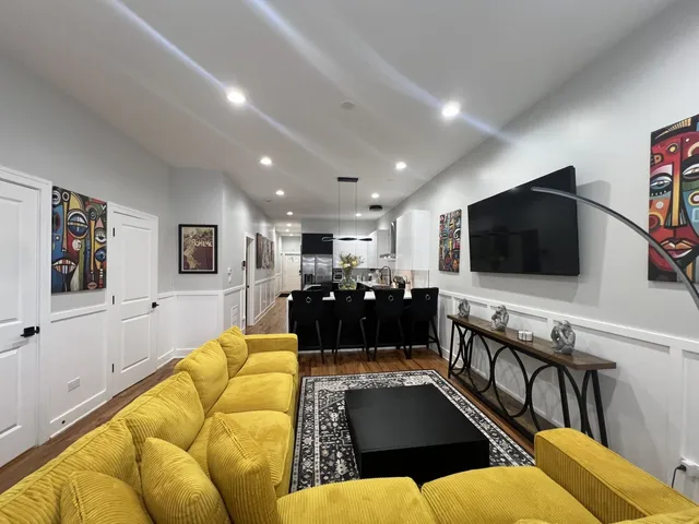 a living room with furniture kitchen view and a flat screen tv