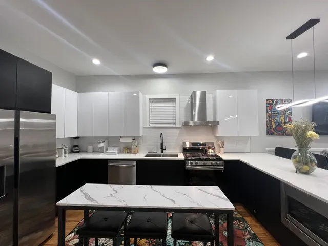 a kitchen with a dining table chairs and refrigerator