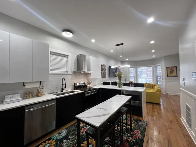 a kitchen with a dining table chairs sink and white appliances
