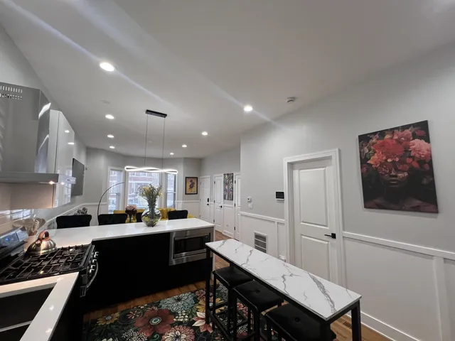 a kitchen with a dining table chairs and white appliances