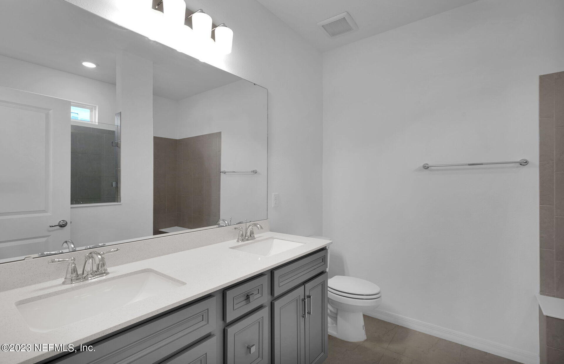 357 Muhly Grass Street Yulee, FL 32097 - Photo 13 of 20 a bathroom with a granite countertop sink a toilet and a mirror