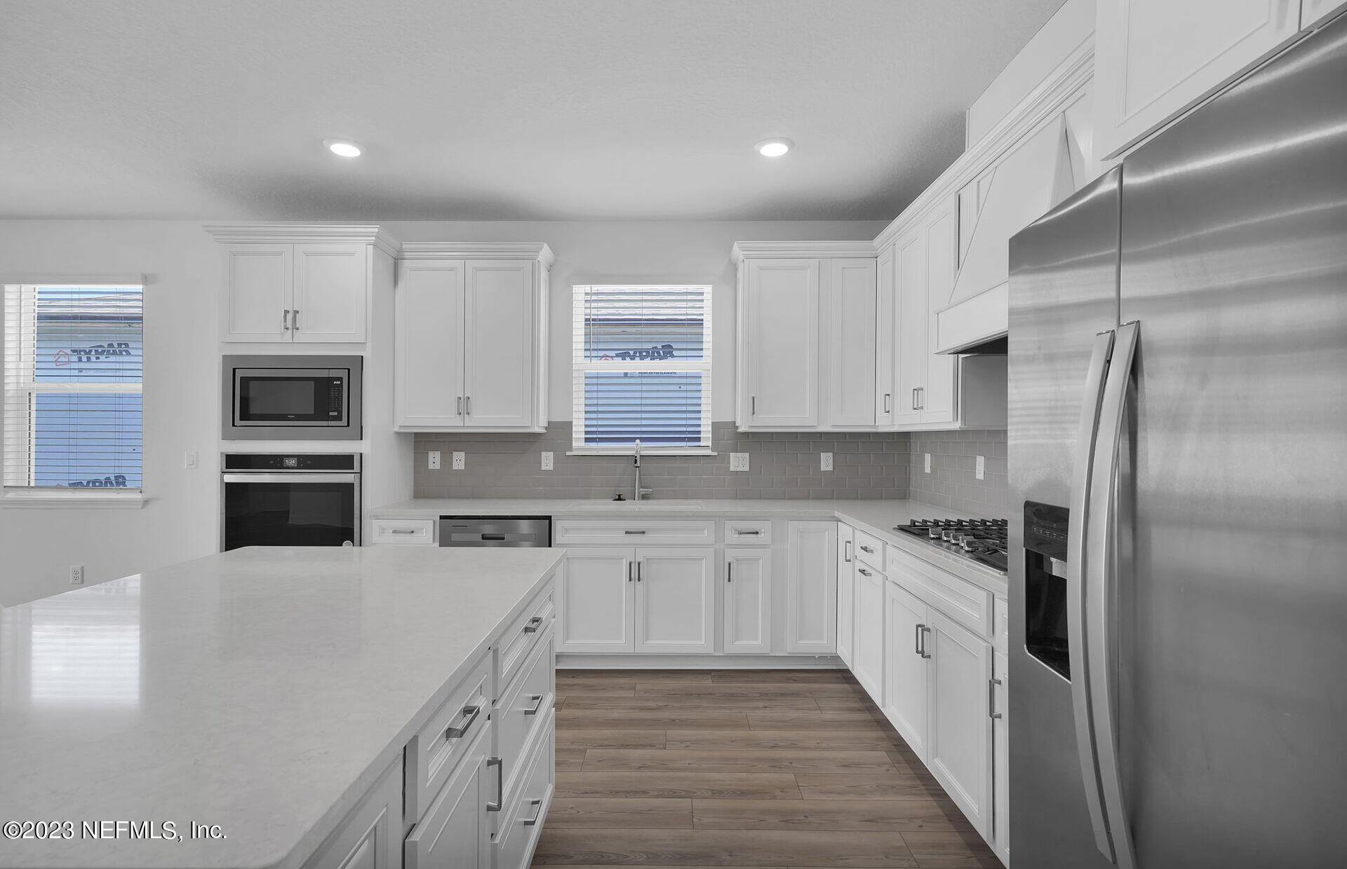 357 Muhly Grass Street Yulee, FL 32097 - Photo 6 of 20 a kitchen with stainless steel appliances granite countertop a stove top oven a sink and a refrigerator