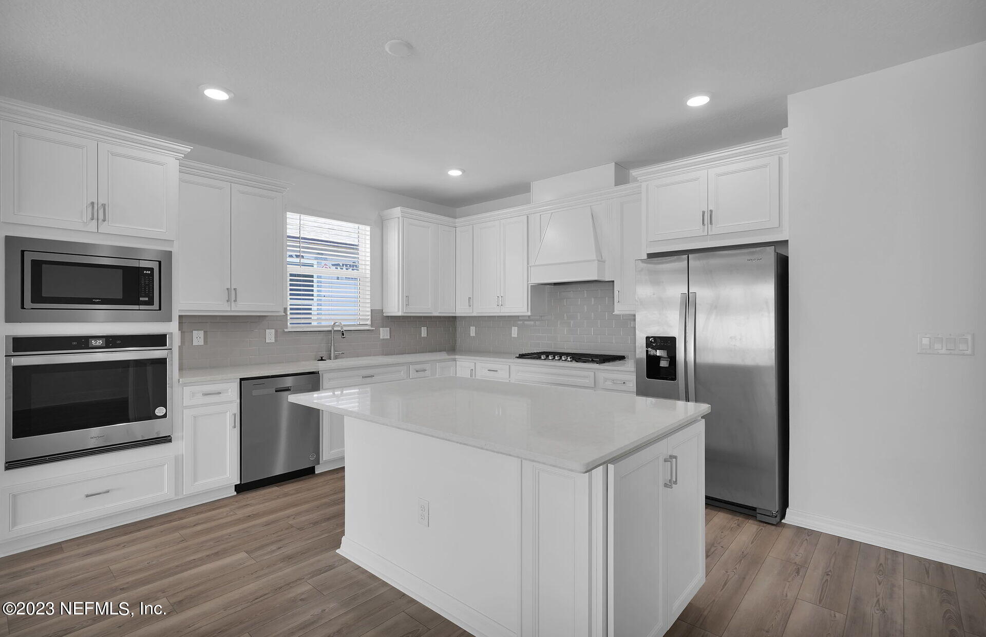 357 Muhly Grass Street Yulee, FL 32097 - Photo 7 of 20 a kitchen with a sink a stove a refrigerator and cabinets