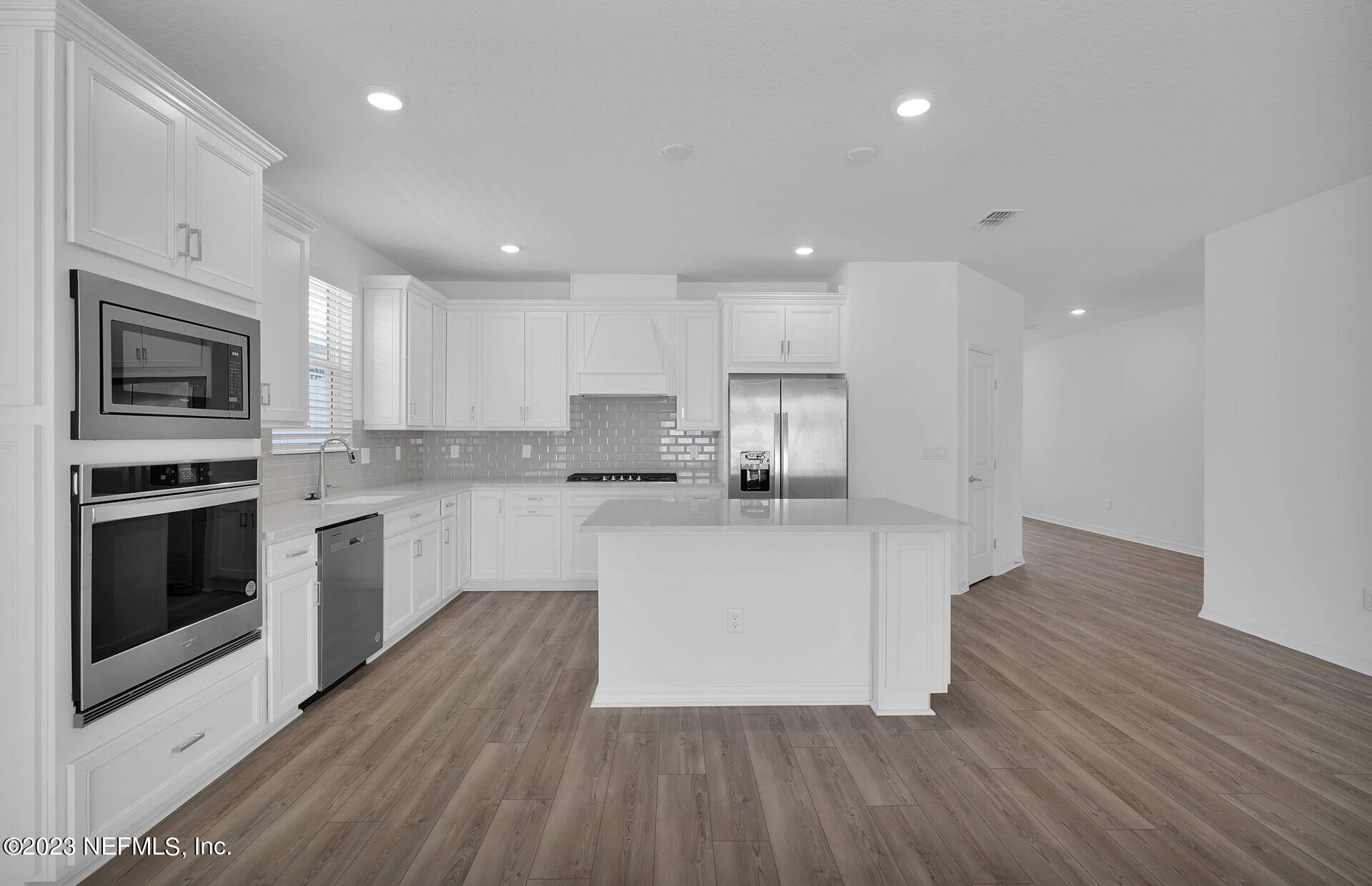 357 Muhly Grass Street Yulee, FL 32097 - Photo 8 of 20 a kitchen with granite countertop a stove top oven and cabinets