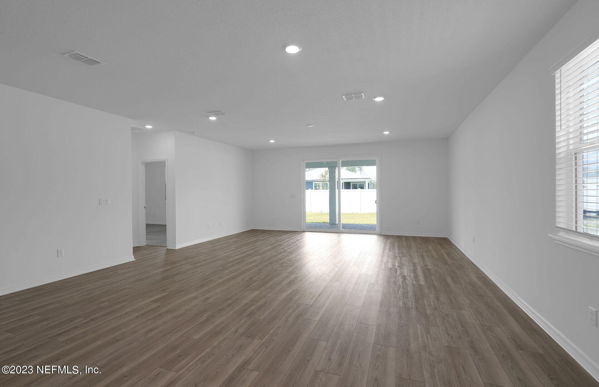 357 Muhly Grass Street Yulee, FL 32097 - Photo 10 of 20 a view of an empty room with wooden floor and a window