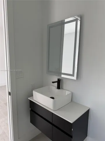 a bathroom with a sink vanity and a mirror