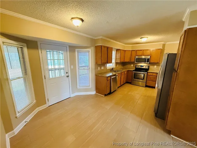 a kitchen with granite countertop a refrigerator and a sink