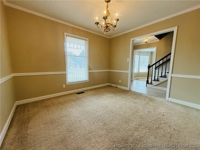 an empty room with a chandelier fan