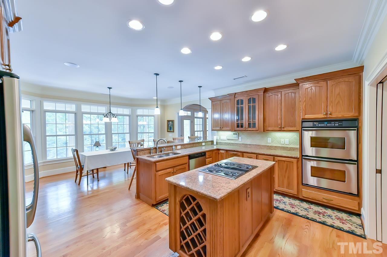 2734 River Forks Road Sanford, NC 27330 - Photo 7 of 30 a kitchen with stainless steel appliances granite countertop a stove top oven a sink dishwasher a dining table and chairs with wooden floor