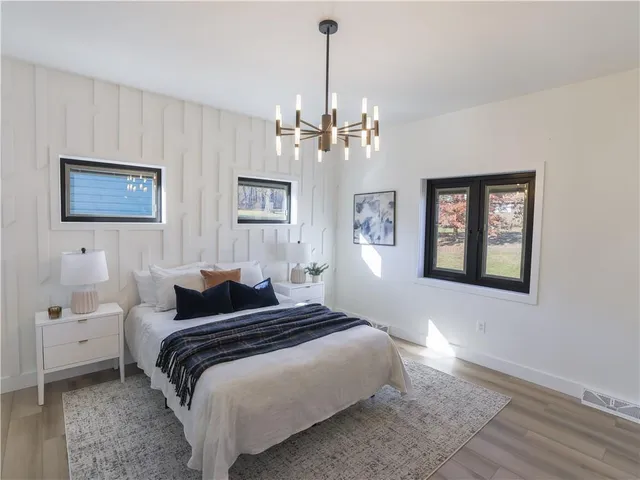 a bedroom with a large bed and a chandelier
