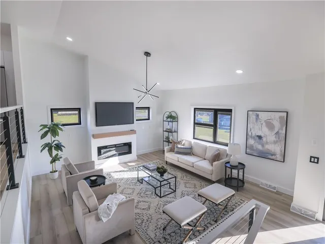 a living room with furniture a flat screen tv and a window