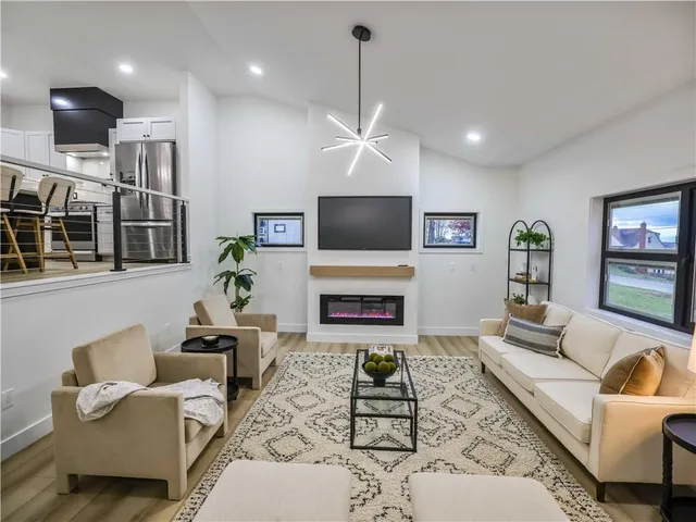 a living room with furniture a flat screen tv and a fireplace