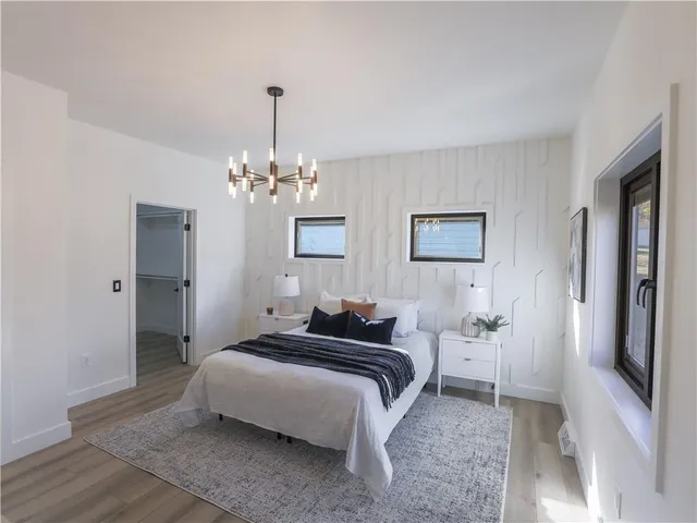 a spacious bedroom with a bed and a chandelier