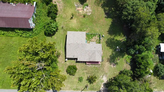 an aerial view of a house with a yard basket ball court and outdoor seating