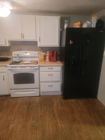 a kitchen with a sink wooden floor and cabinets
