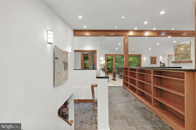 a living room with furniture kitchen view and a large window