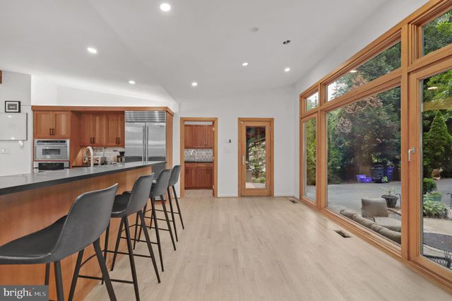 a large kitchen with stainless steel appliances wooden cabinets and a sink