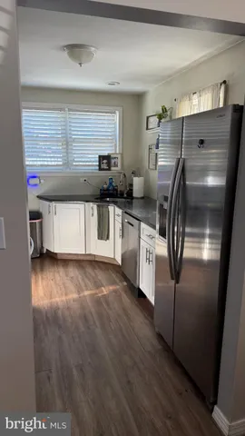 a kitchen with stainless steel appliances a refrigerator sink and white cabinets