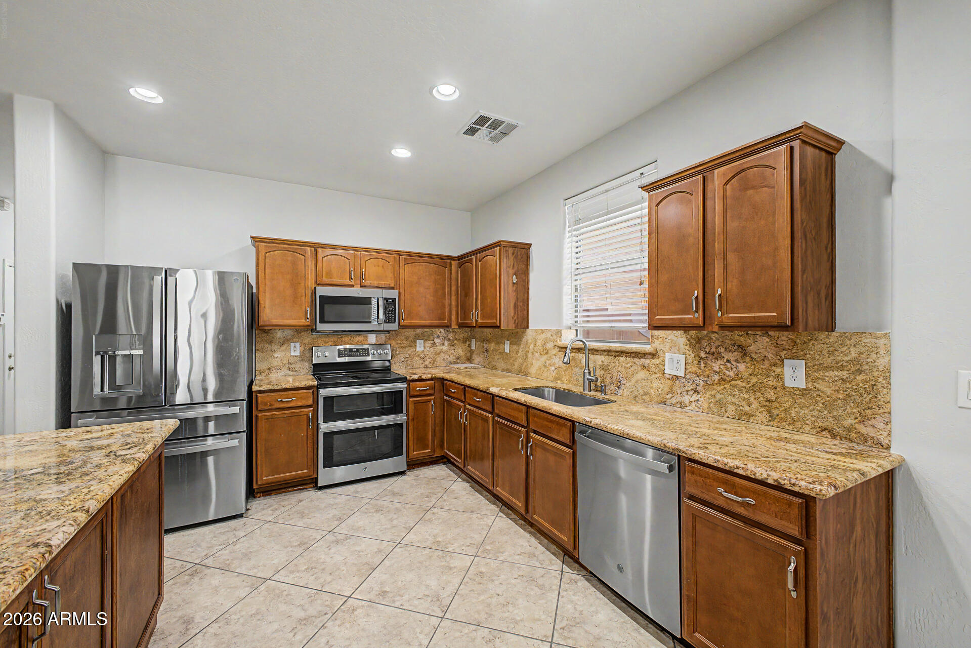 45449 West Tucker Road Maricopa, AZ 85139 - Photo 11 of 46 a kitchen with stainless steel appliances granite countertop a sink stove and refrigerator