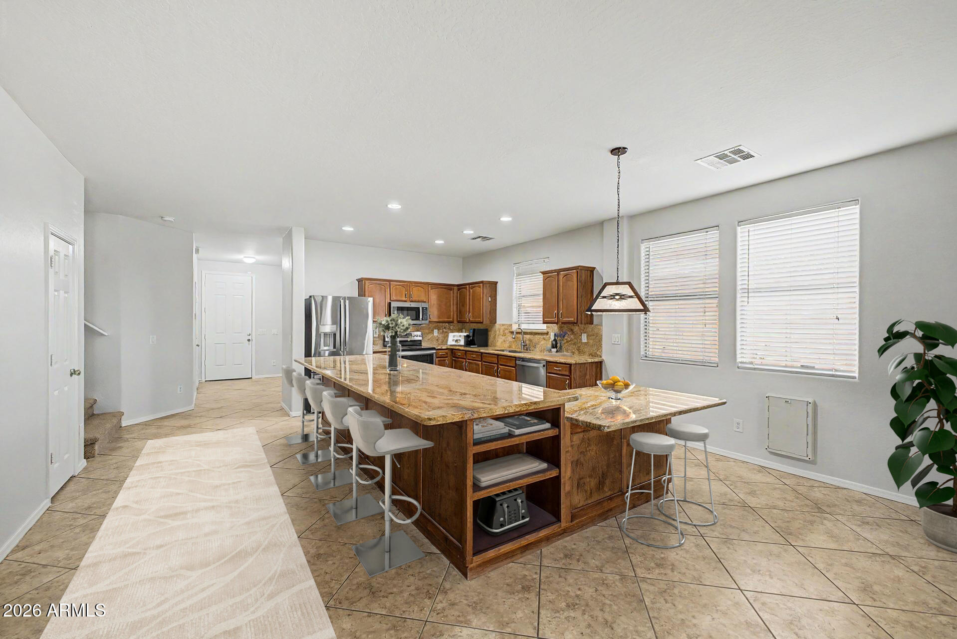 45449 West Tucker Road Maricopa, AZ 85139 - Photo 8 of 46 a dining hall with stainless steel appliances kitchen island granite countertop a table and chairs in it