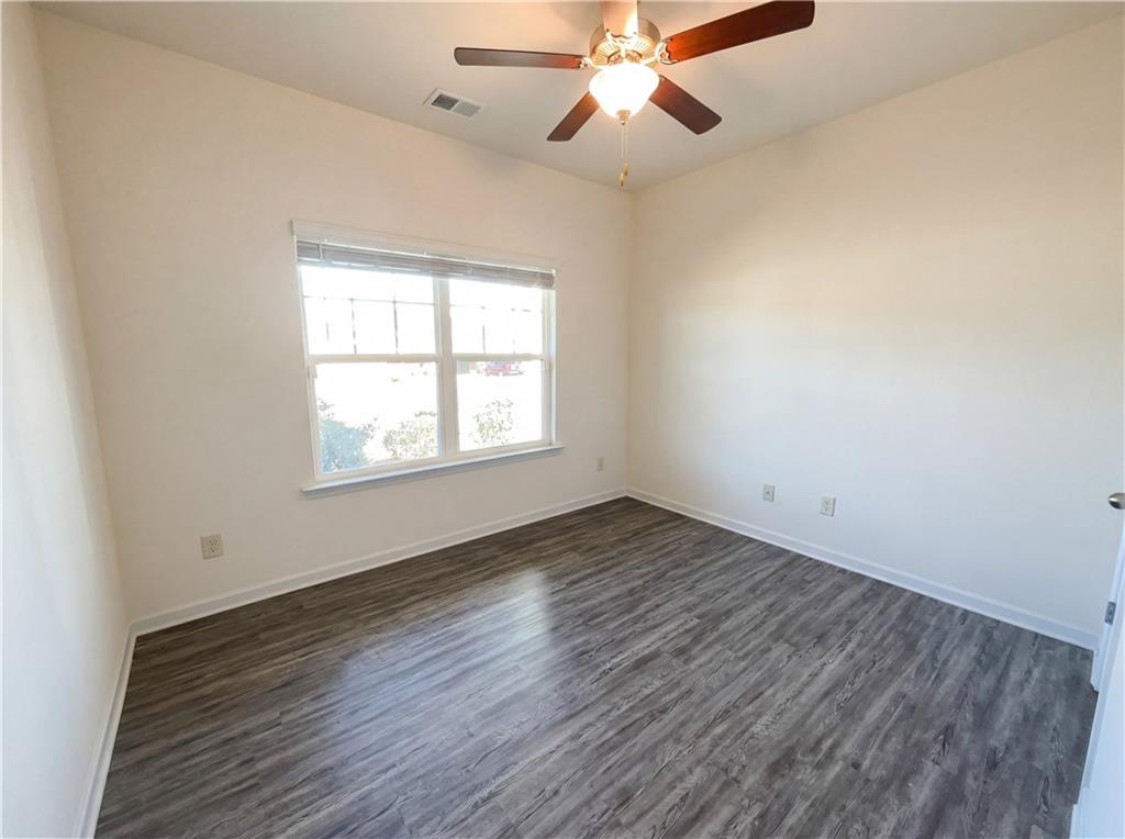 2682 North Broad Street Extension Northeast Rome, GA 30161 - Photo 20 of 23 an empty room with wooden floor fan and windows