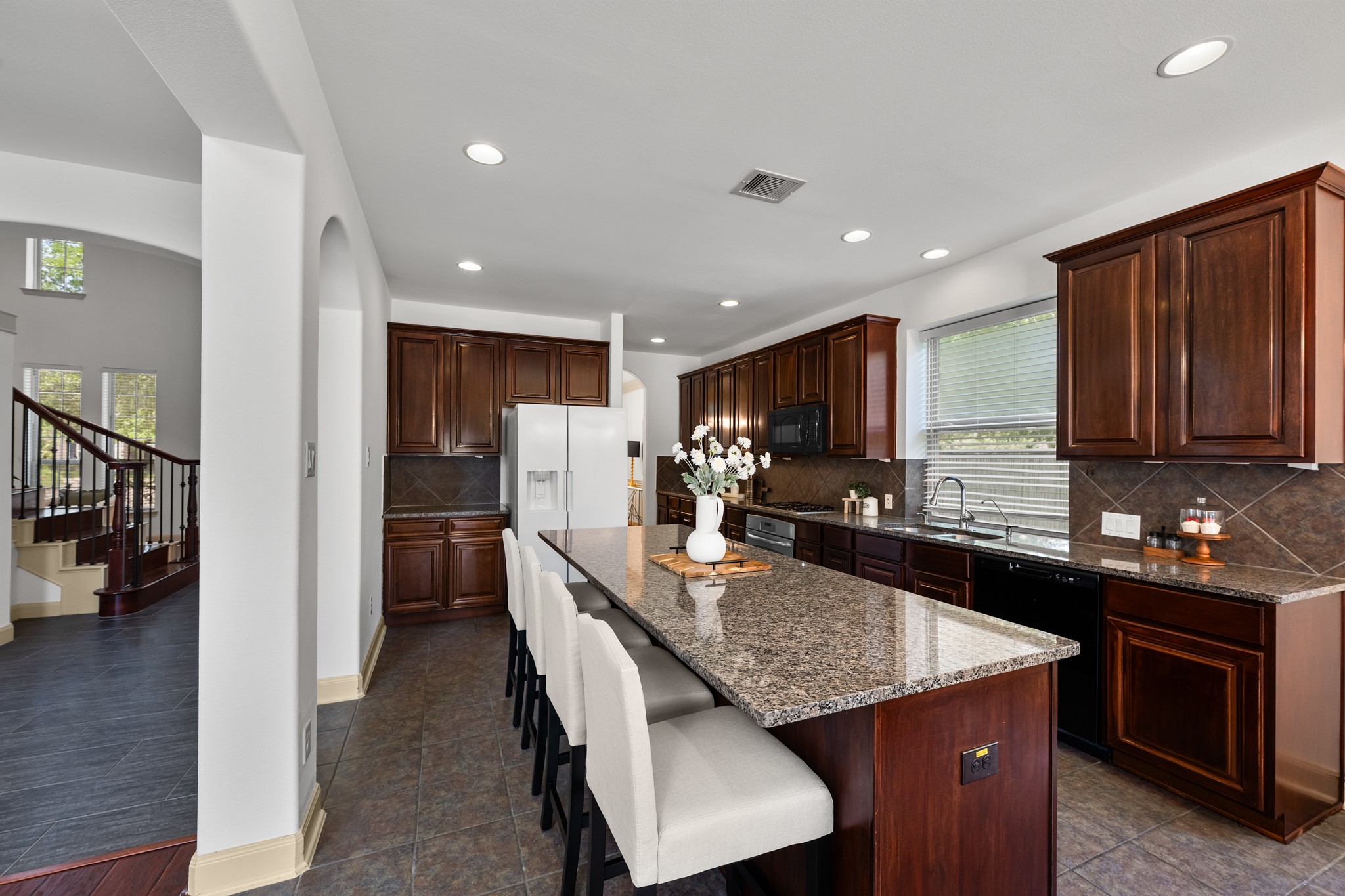 4603 Red Hawk Court Sugar Land, TX 77479 - Photo 17 of 50 a kitchen with granite countertop kitchen island stainless steel appliances a sink stove and refrigerator