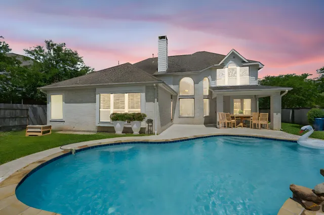 a front view of a house with swimming pool having outdoor seating