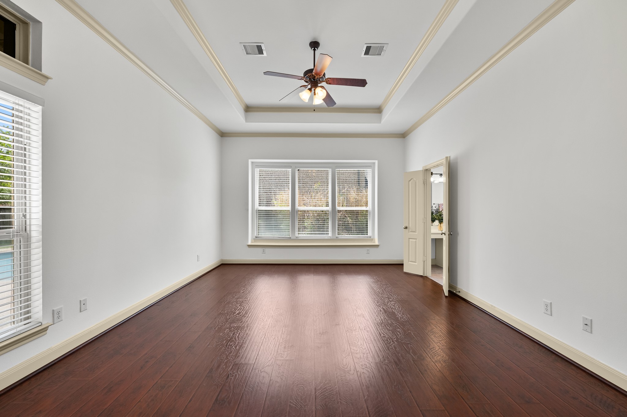 4603 Red Hawk Court Sugar Land, TX 77479 - Photo 21 of 50 an empty room with wooden floor chandelier fan and windows