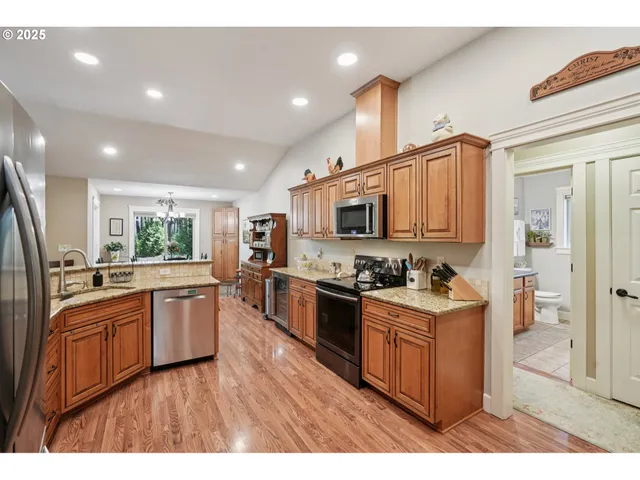 a kitchen with stainless steel appliances kitchen island granite countertop a stove top oven and sink