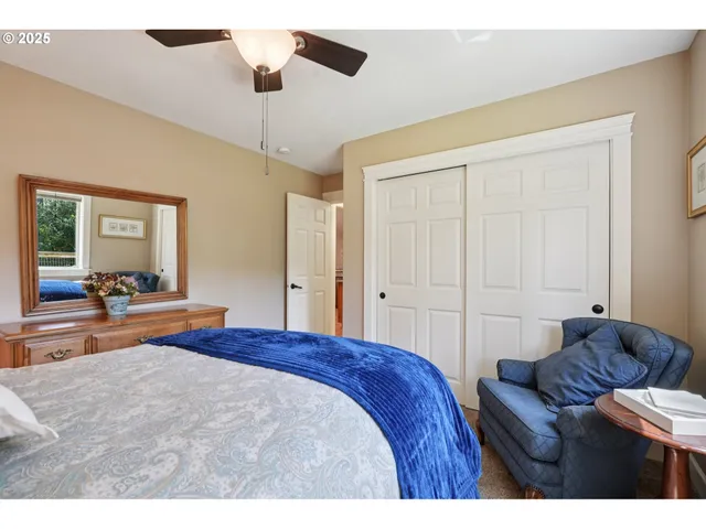 a bedroom with a large bed and ceiling fan