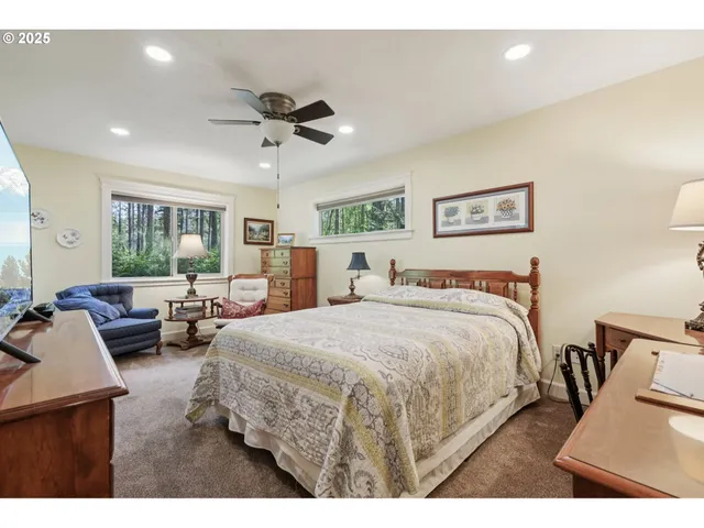 a spacious bedroom with a bed a couch and a large window