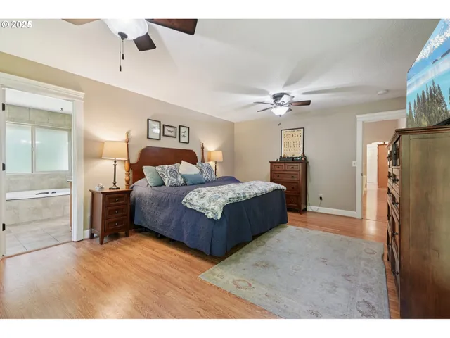 a bedroom with a large bed a chandelier and dresser