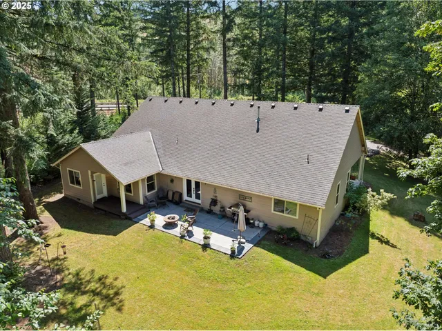 an aerial view of a house with swimming pool and large trees