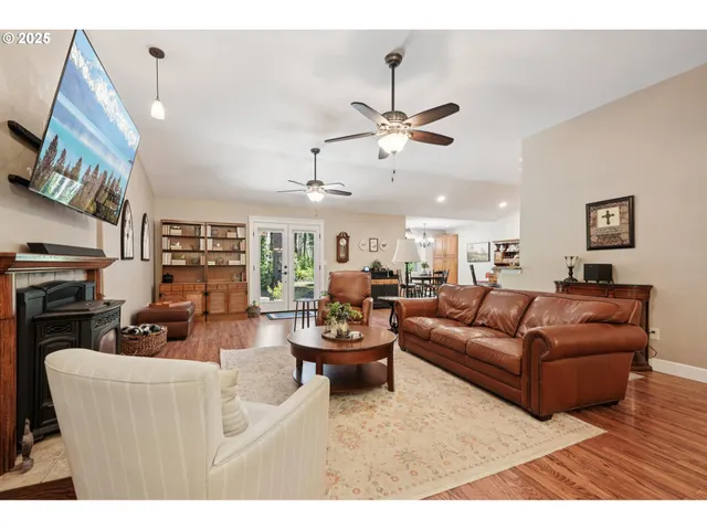 a living room with furniture kitchen view and a chandelier